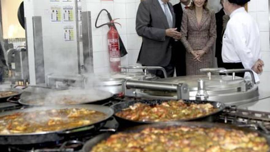 Letizia y Casanova visitan la cocina de la entidad; la princesa recibe de un usuario del centro de día una felicitación navideña, y la comitiva, en el comedor de la entidad.