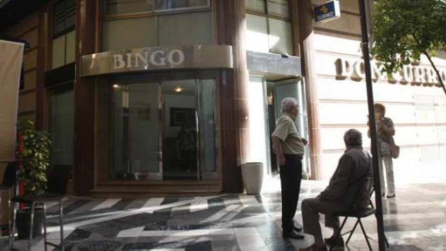 Varios viandantes junto a una sala de bingo situada en el Centro de Málaga capital.