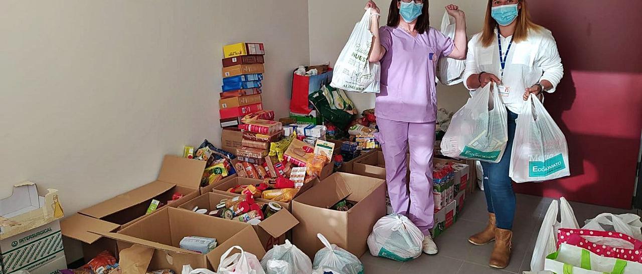 Elsa Argüelles y María García, con algunos de los alimentos recogidos en el Credine de Barros.