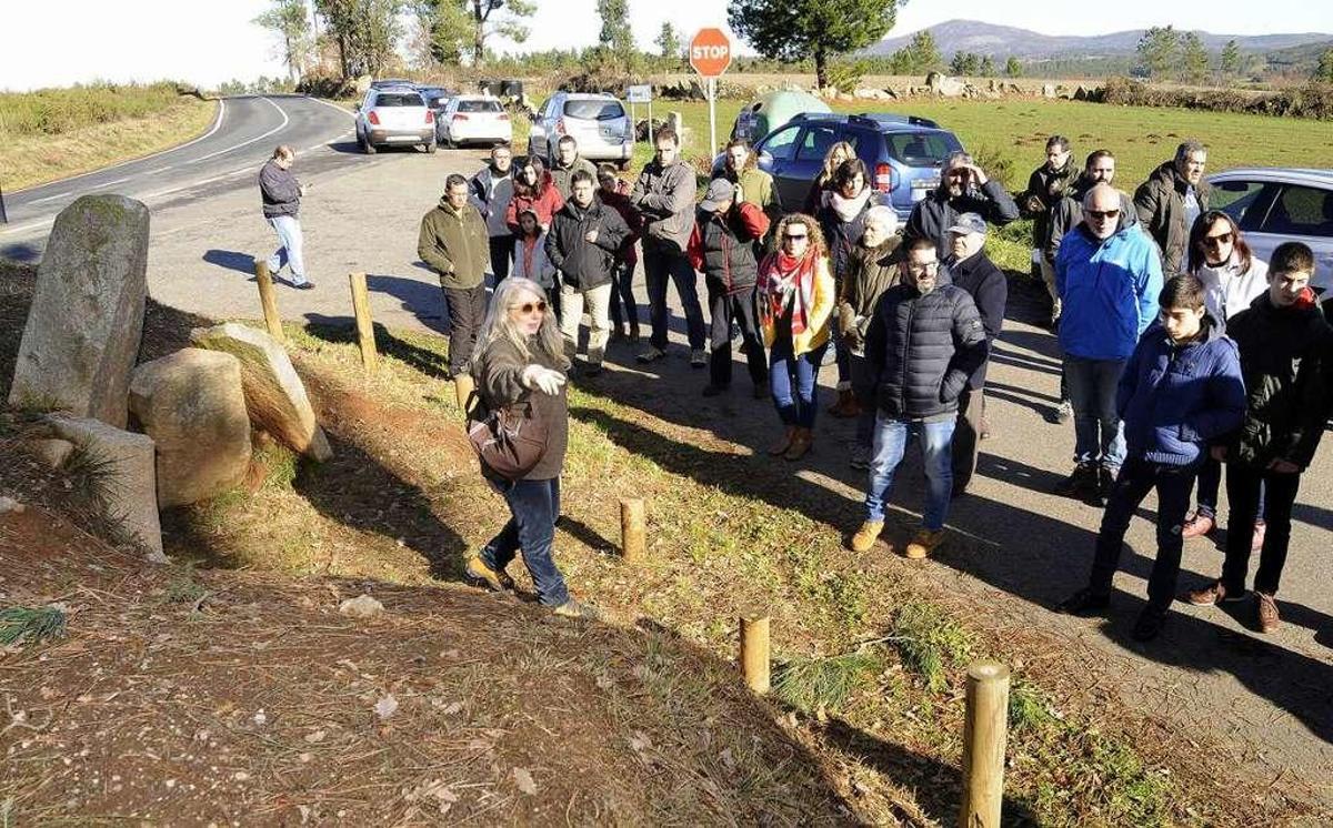 La arqueóloga María José Bóveda indica a los participantes las dimensiones de la mámoa. // Bernabé/J.L.