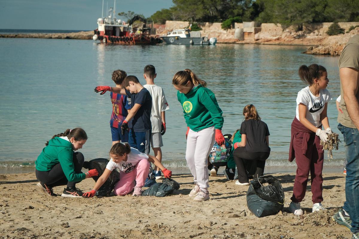 Alumnos del CEIP Sant Rafel y el CEIP Sant Antoni buscan residuos en la arena.
