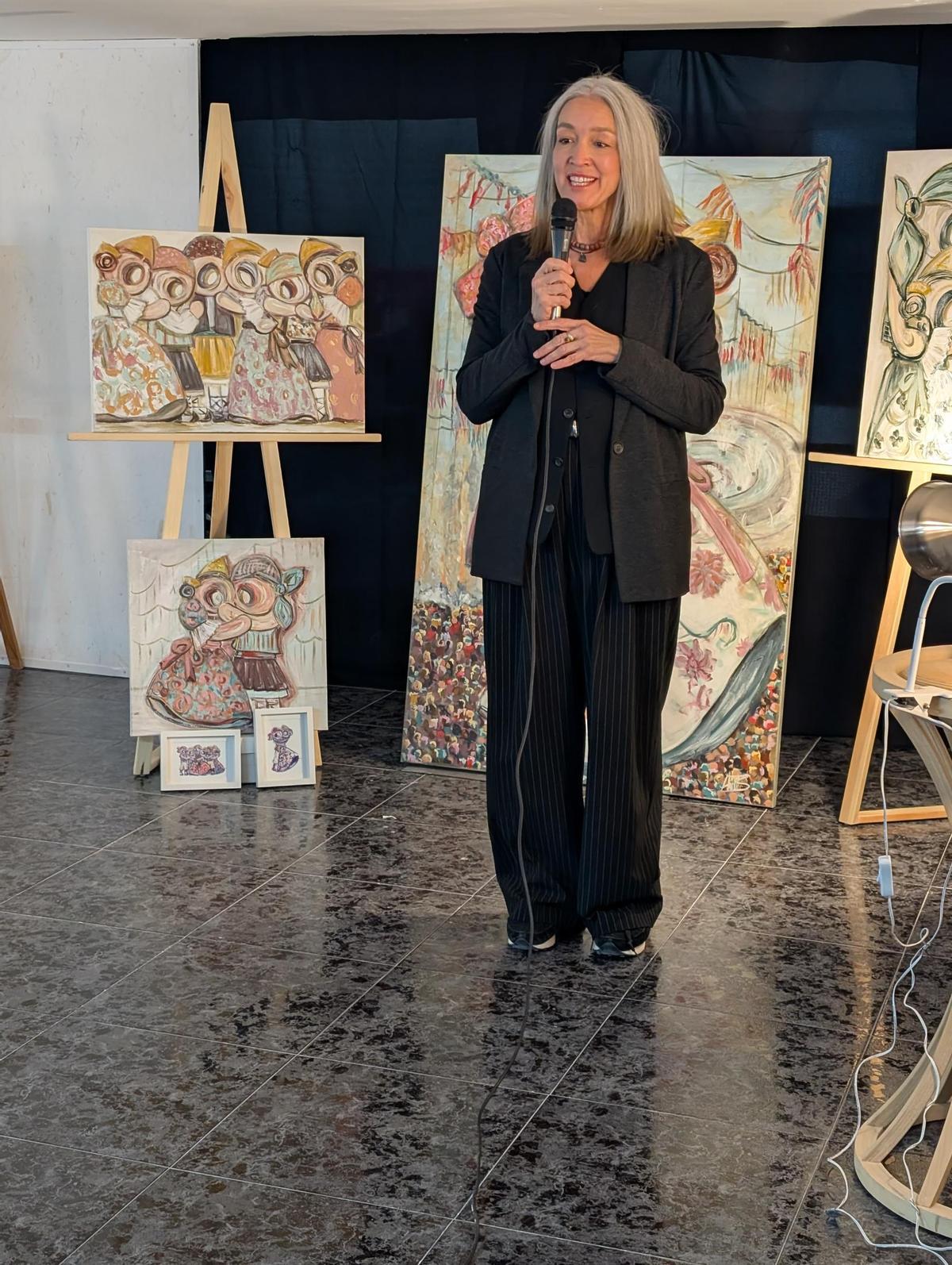 La artista con sus cuadros.