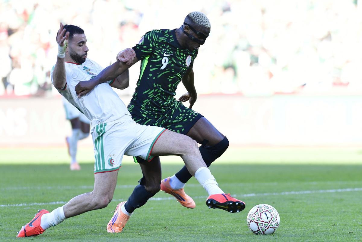 Victor Osimhen, de Nigeria, ante Ramiz Zerrouki, de Algeria, en la copa África
