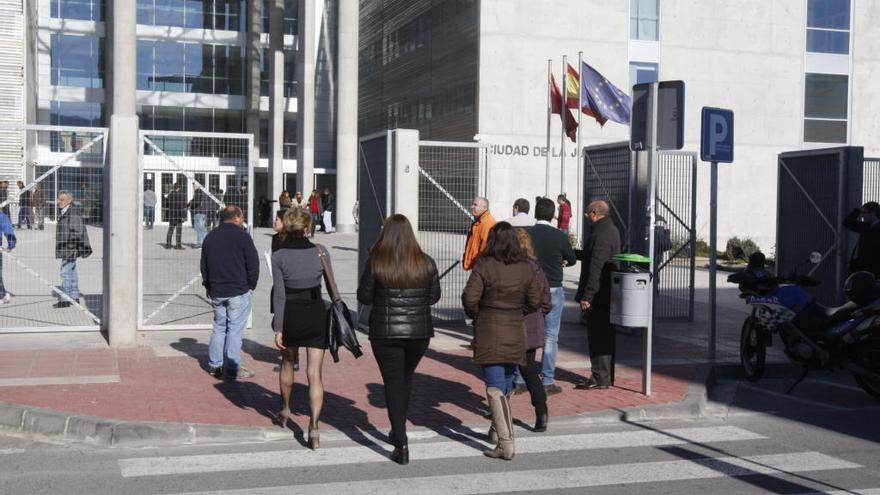 Gente entrando por la puerta principal de la Ciudad de la Justicia de Murcia.