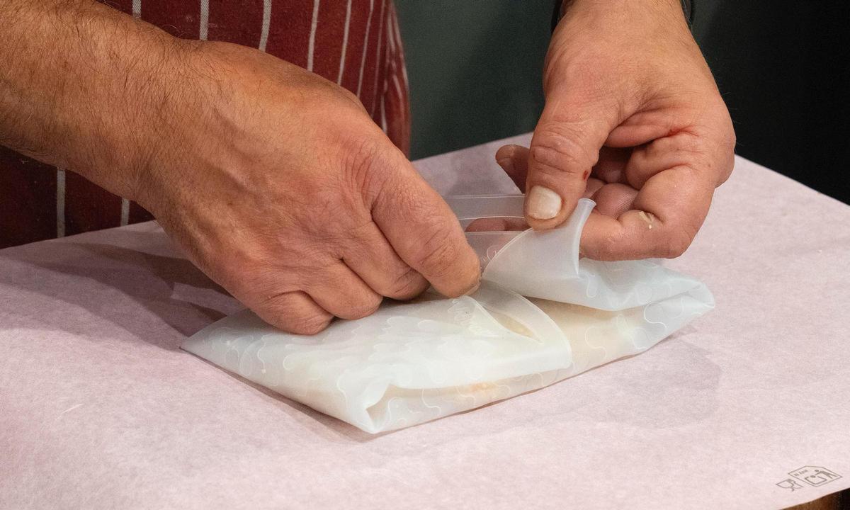 Miquel Hernández envuelve en el Mercat de Santa Caterina una compra con el envoltorio de silicona de Roll'eat.