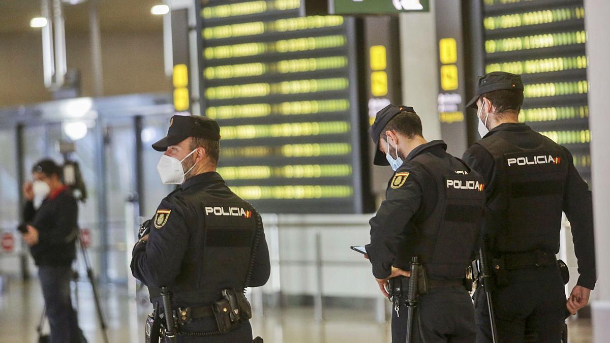 Tres agentes esperan en el interior de la terminal la salida de los pasajeros procedentes de Las Palmas de Gran Canaria, ayer. | EDUARDO RIPOLL