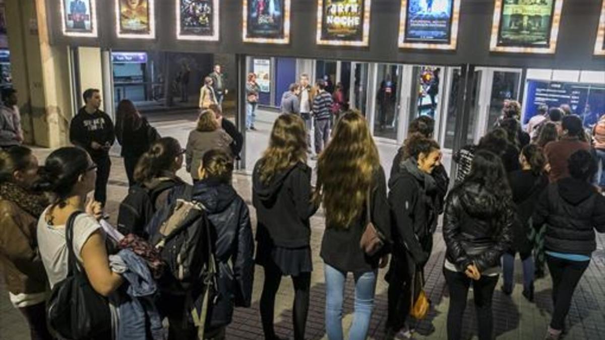 Adolescentes hacen cola para entrar en un cine en Barcelona.