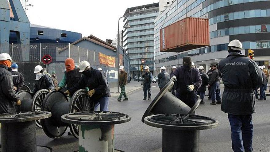 Trabajadores de Naval Gijón han cortado hoy, por segundo día consecutivo, la circulación de vehículos en la calle de Mariano Pola, frente al astillero, en protesta por el expediente de extinción de contratos que presentó la compañía y que afecta a toda la plantilla.