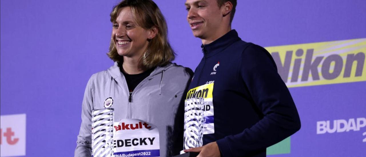 Katie Ledecky y Leon Marchand posan con los trofeos que los acreditan como los mejores nadadores del Mundial.