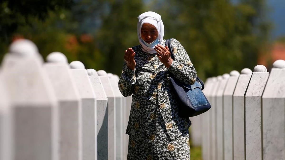 Una mujer reza junto a las tumbas de los fallecidos en el memorial de Potocari.