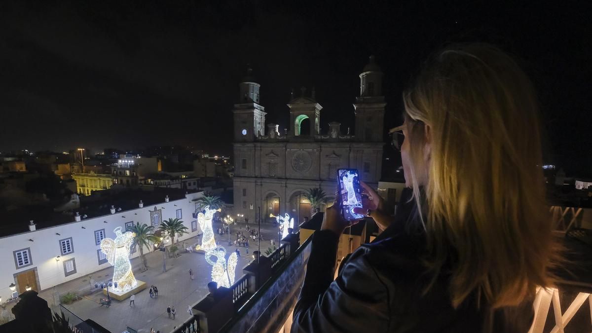 Una clienta toma una foto de los ángeles de luz desde la terraza del Boutique Hotel Cordial Plaza Mayor de Santa Ana.