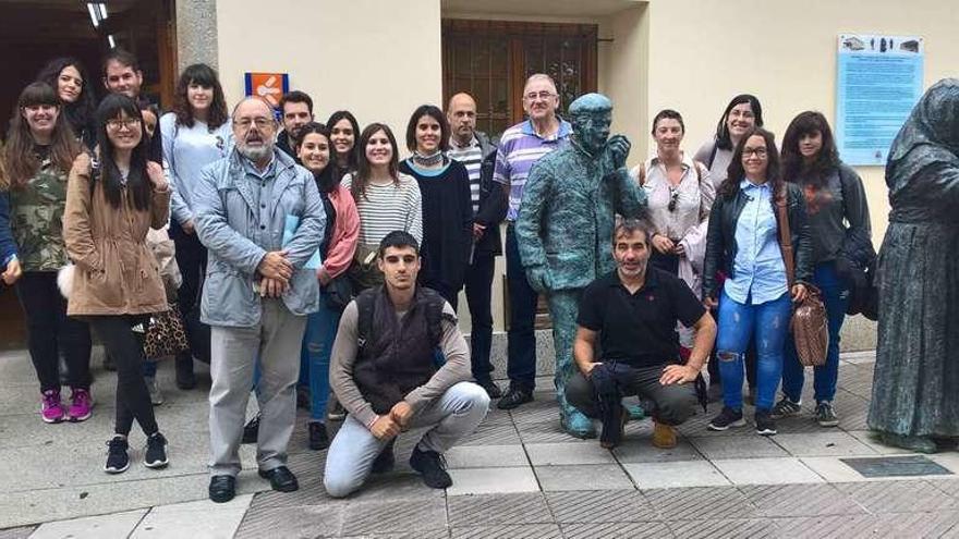 Participantes en la visita a Boal, junto al monumento dedicado a la emigración en la capital del concejo.