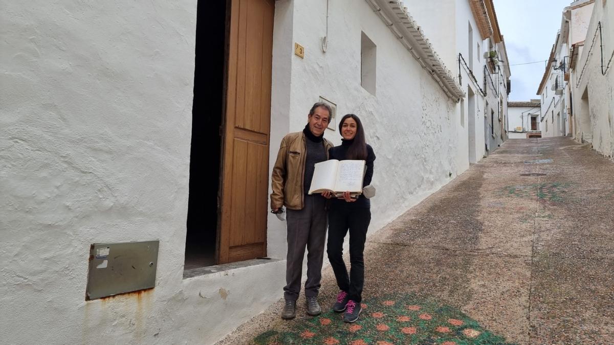 Paco e Irene, en la puerta de la casa que alberga el molino, muestran uno de los libros de Sebastià, el último molinero
