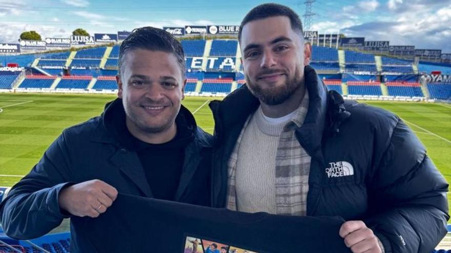 David Acosta, a la izquierda, sostiene una camiseta con el lema ‘Esto es fútbol, papá’ en el Coliseum junto a Rafa Escrig.