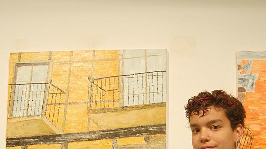 María Oterino aparece ante sus obras pictóricas.