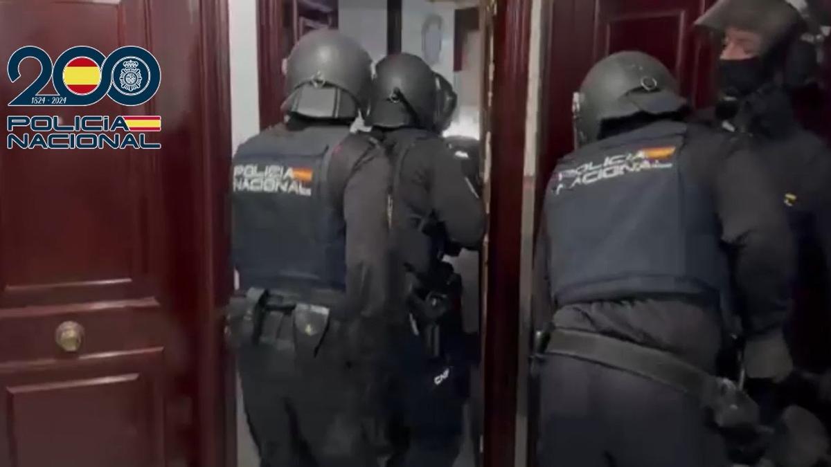 Agentes de la Policía entran en uno de los domicilios registrados en la operación para desarticular a una red que estafaba dinero a través de técnicas de 'vishing'.