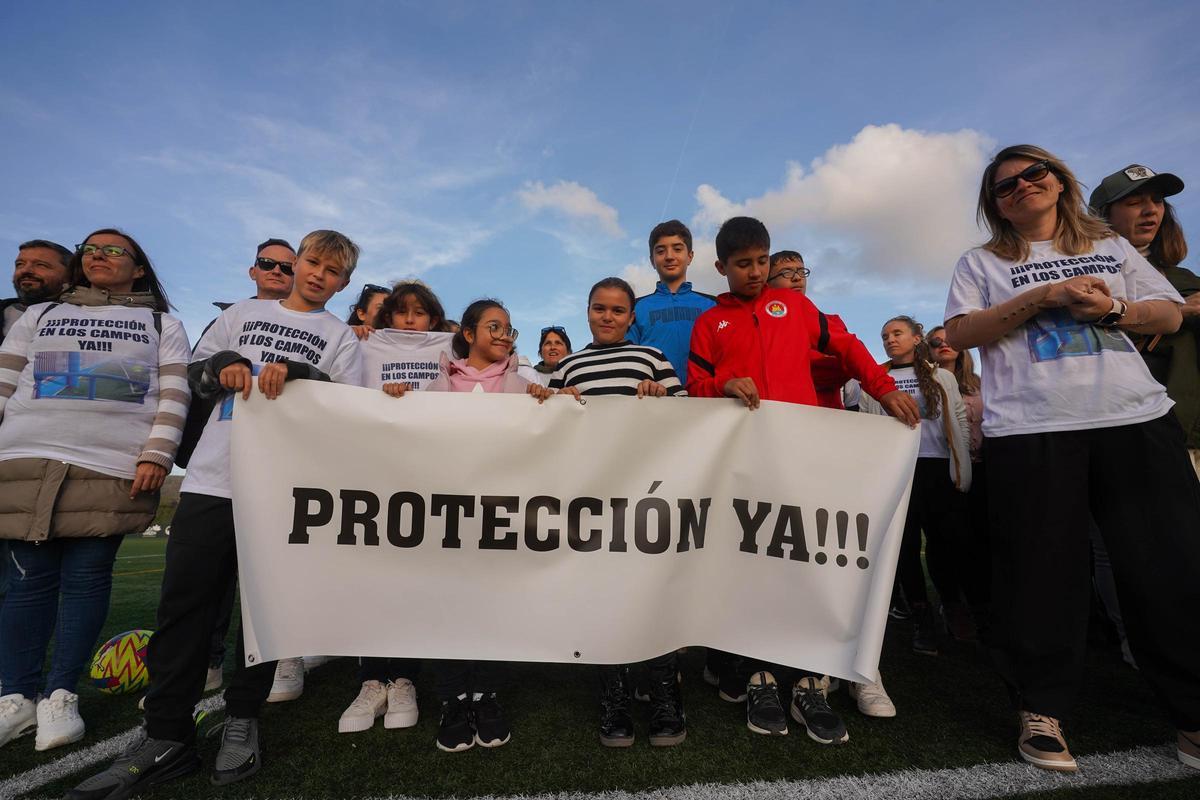 Izan y su madre Cristina sujetan la pancarta junto a otras familias