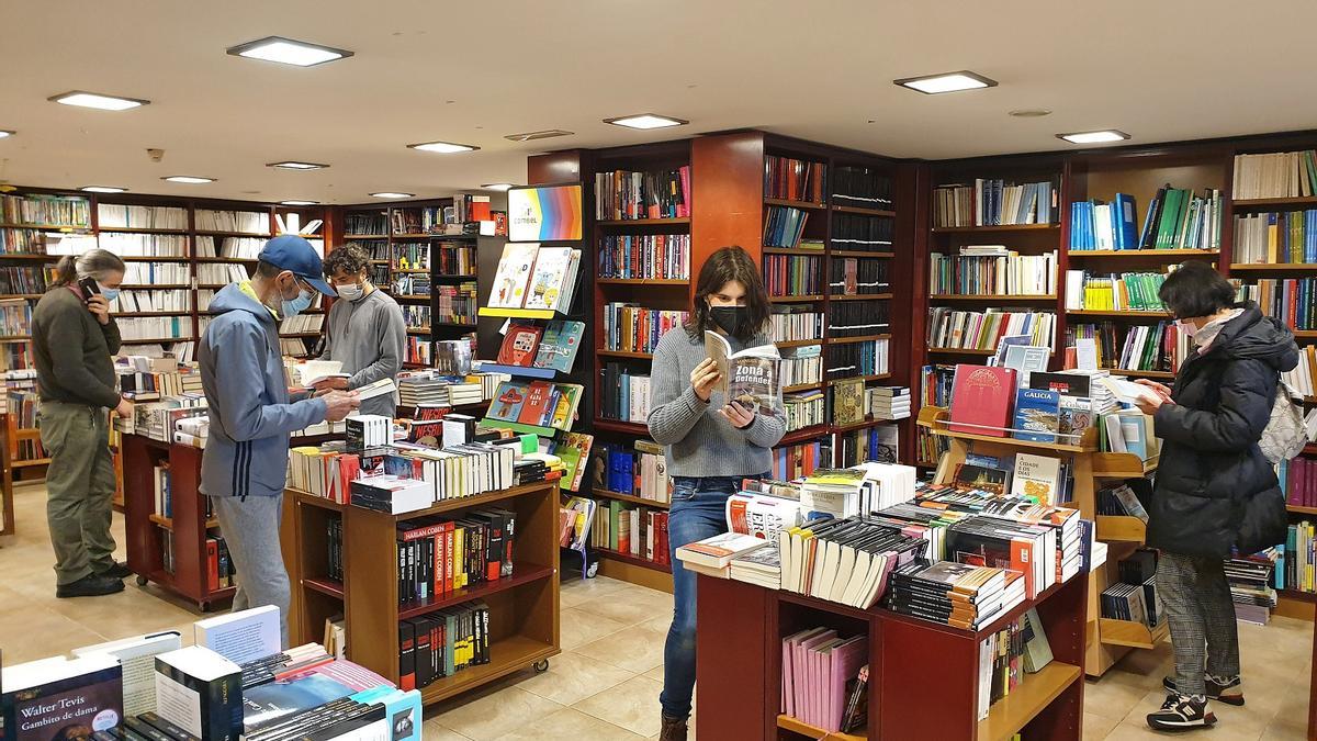 Clientes ojean varias obras en la librería Librouro, una de las adheridas al bono cultura de la Xunta