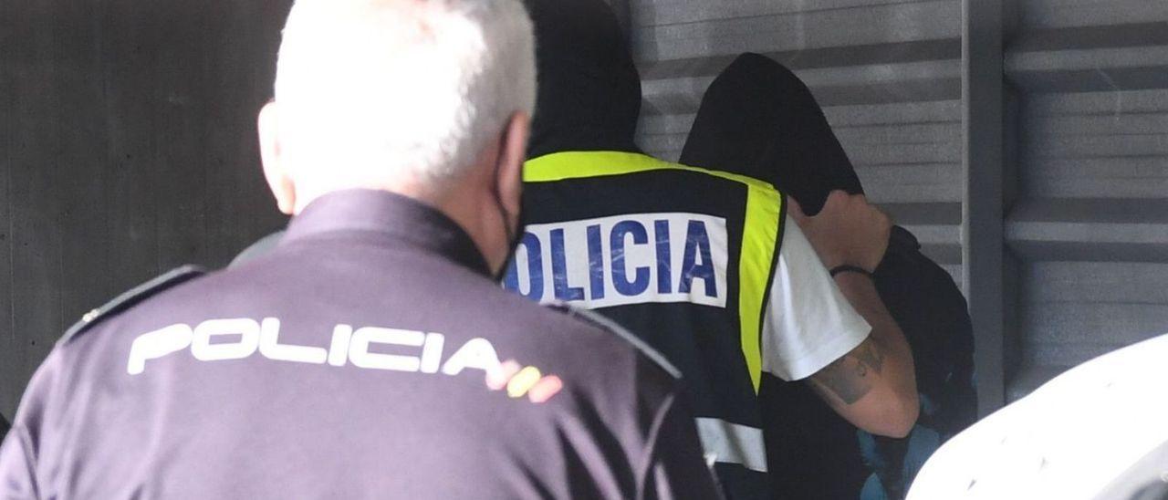 Agentes de la Policía Nacional, con uno de los investigados, en los juzgados.