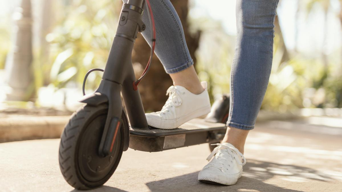 Una joven subida a un patinete eléctrico en una imagen de archivo