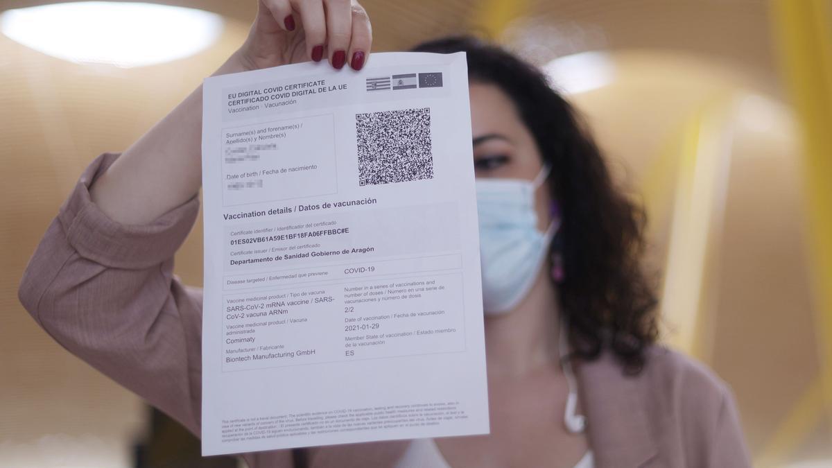 Una mujer porta el pasaporte covid de vacunación