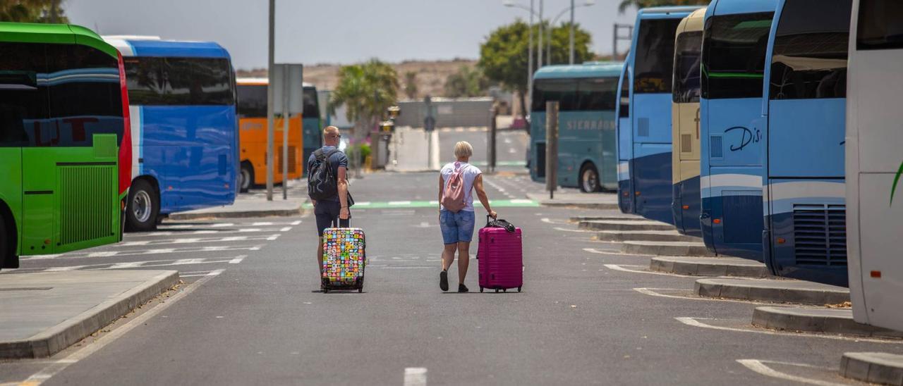 Una pareja de turistas extranjeros arrastra sus maletas a la salida del aeropuerto Tenerife Sur. | | CARSTEN W. LAURITSEN