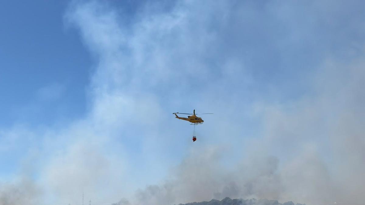 Un helicóptero del Plan Infoca descargando agua sobre el incendio declarado en un paraje de San Roque este miércoles 5 de agosto.