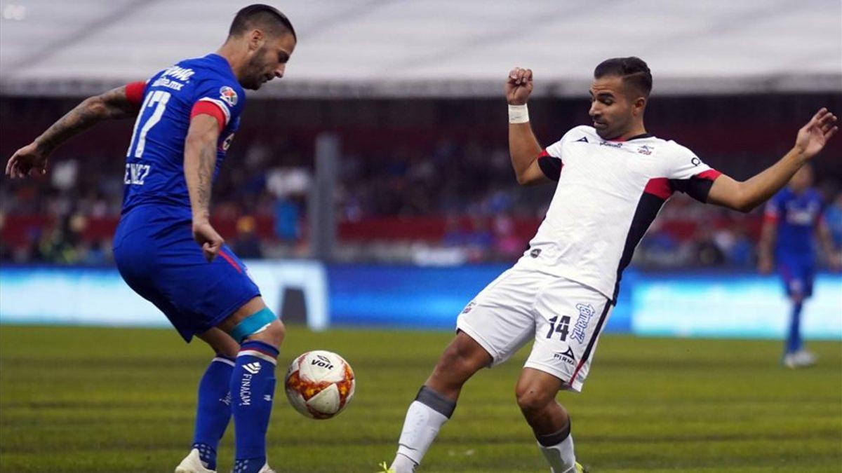 Édgar Méndez gana el balón bajo unas pésimas conidciones del pasto en el estadio Azteca