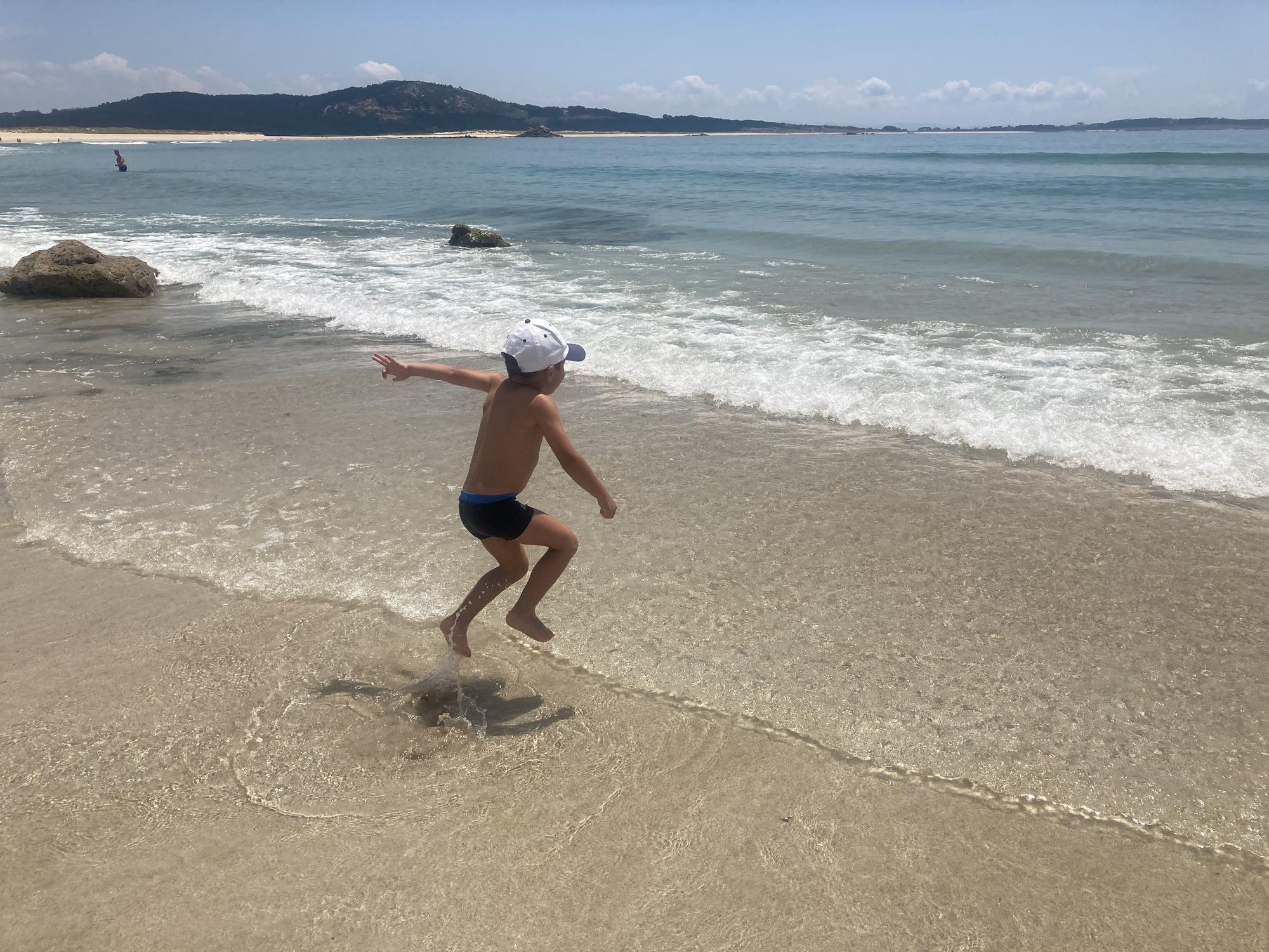 Un niño se baña en la playa.