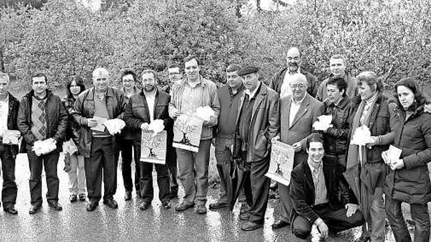 Los alcaldes de la Comarca de la Sidra y otras autoridades, frente a varios pumares floridos, en la sede del Serida.