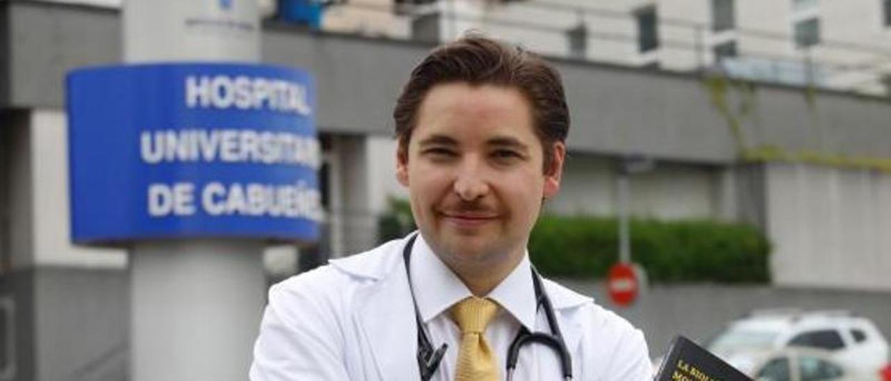 Pablo Argüelles, con su libro, frente al Hospital de Cabueñes de Gijón. | Ángel González