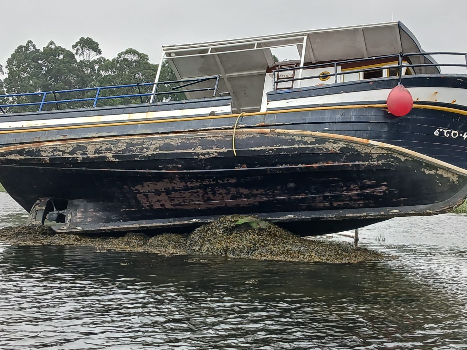 El barco parece acomodado sobre las piedras.