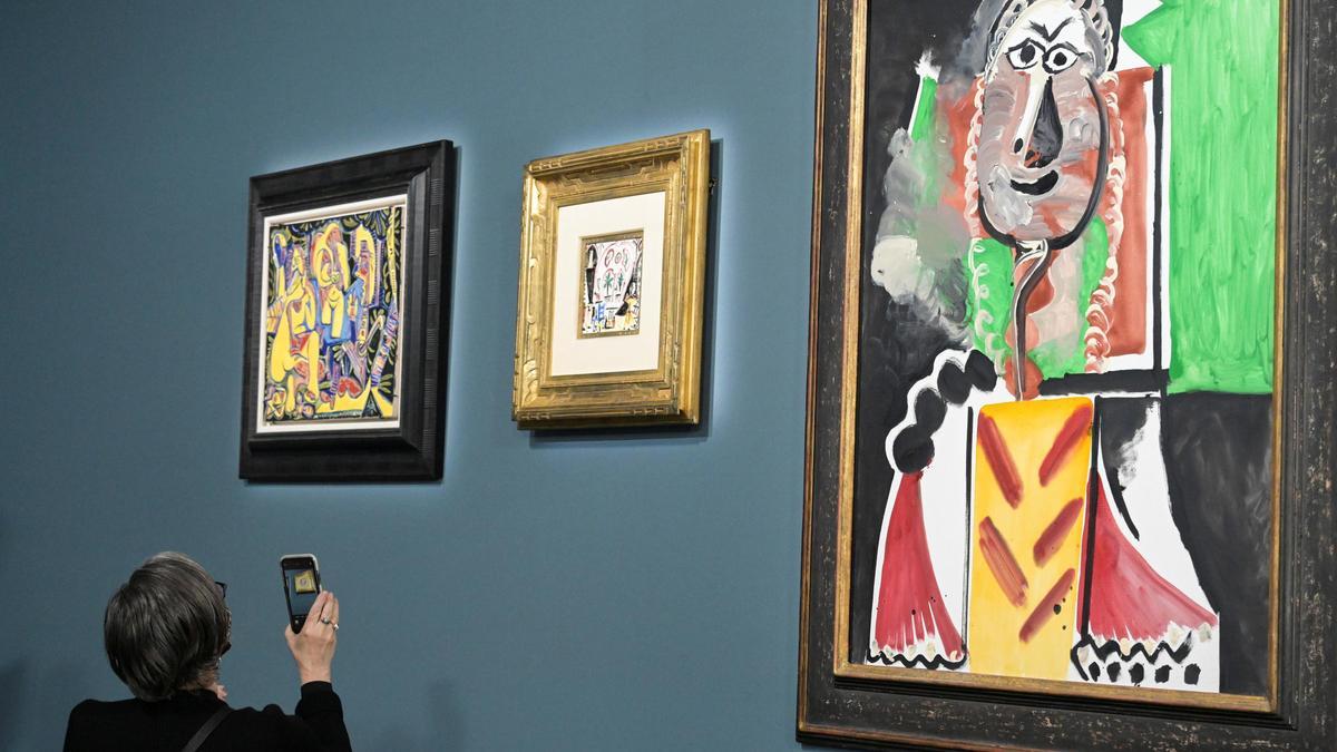 Un asistente fotografía un cuadro antes de la subasta de 11 cuadros y obras de Picasso en el Hotel Bellagio de Las Vegas.
