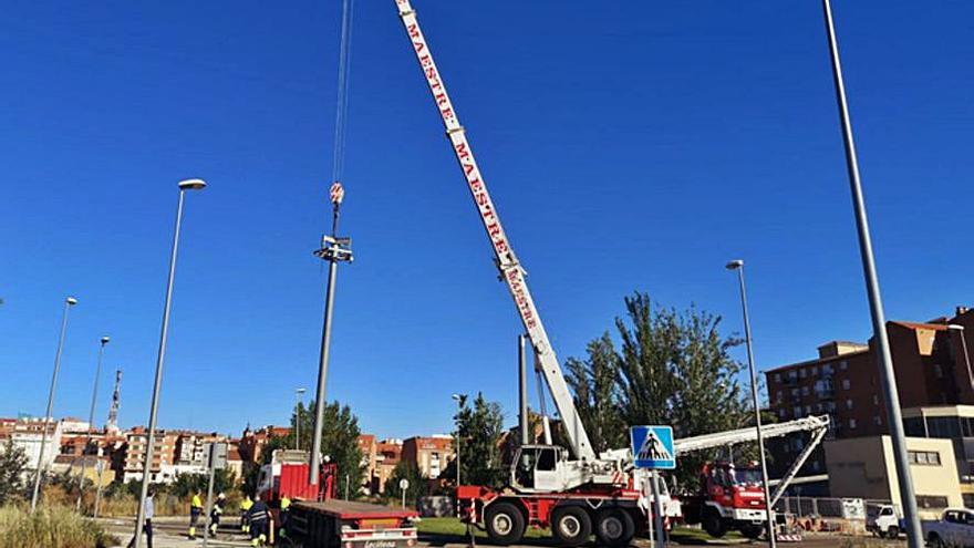 Los bomberos y una grúa para la instalación de la farola. | E. P.