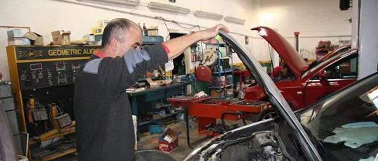 Un mecánico revisa el estado del motor de un vehículo en un taller, en una imagen de archivo.
