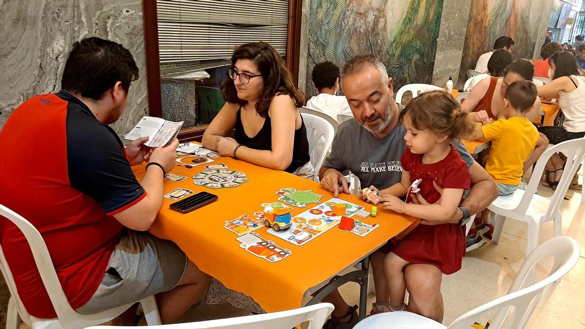 César y su hija en una de las mesas para el juego del festival.