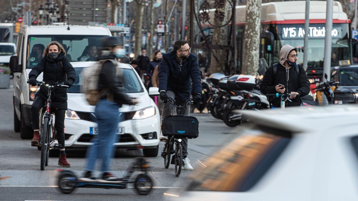 Bicis, patinetes, coches y un autobús, una típica postal de la Barcelona del siglo XXI.