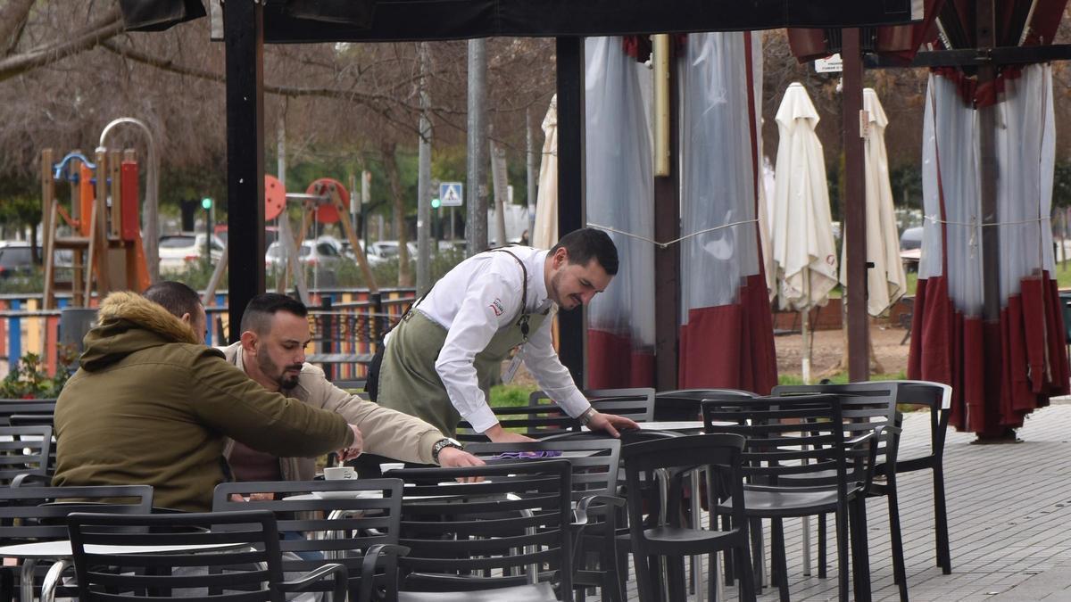Un camarero trabaja en la terraza de un bar.