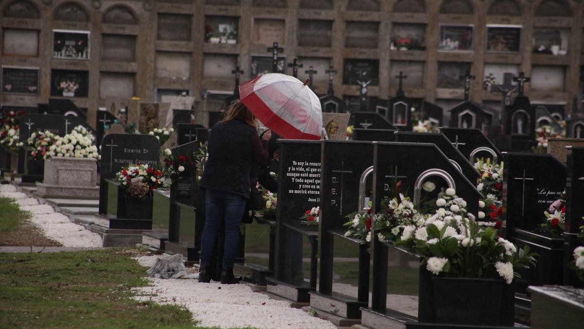 Dos personas visitan un familiar enterrado en el cementerio de Boisaca en Santiago