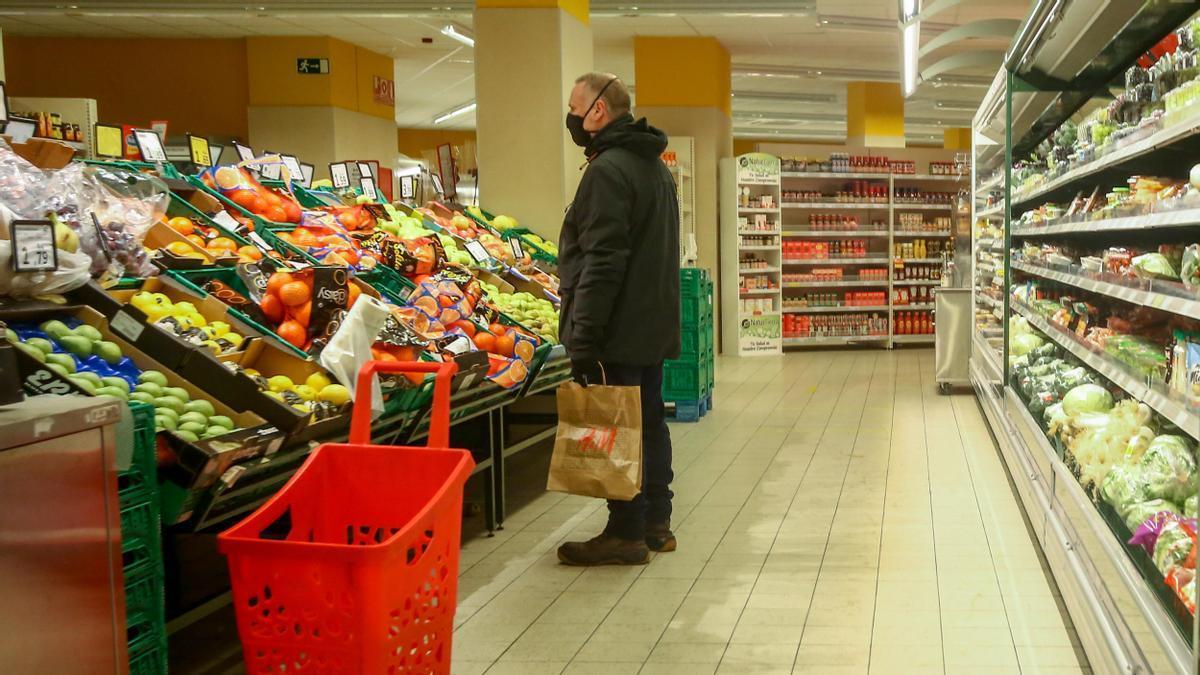 Un hombre en la sección de frutería de un supermercado.