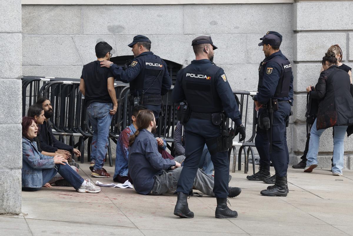 MADRID, 30/03/2023.- Efectivos de la Policía Nacional detienen a unos activistas de Rebelión Científica que lanzaron pintura roja en la Puerta de Los Leones del Congreso este jueves en Madrid. EFE/ J.J. Guillén