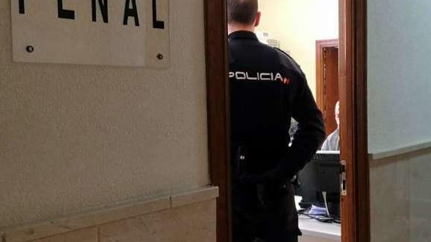 Un Policía espera a los detenidos en la sala de lo Penal.