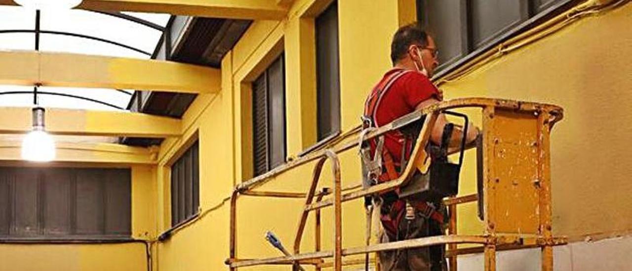 El operario Javier Luna, pintando los muros. El operario Javier Luna, pintando los muros.