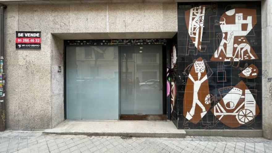 Imagen de la fachada de la tienda de pavimentos de la calle Santa Cruz de Marcenado con el mural de César Manrique que recrea el trabajo en una obra.