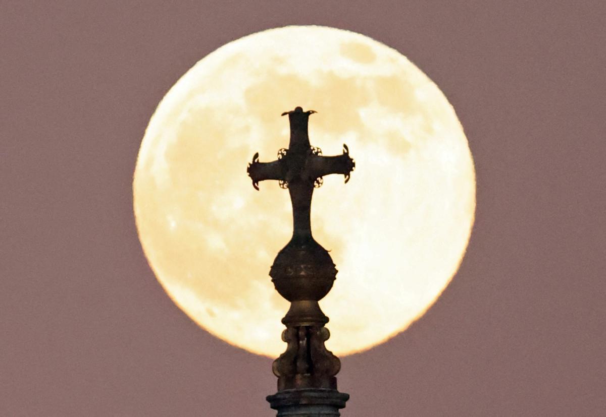 La cruz que corona la cúpula de Saint Paul’s, la catedral anglicana de Londres, con la primera luna llena de este año.