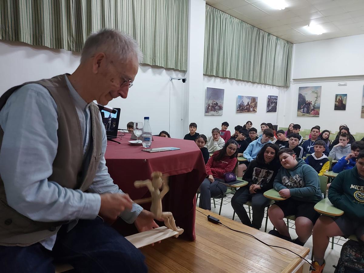 Joaquín Hernández hace bailar un títere ante la mirada de los estudiantes.