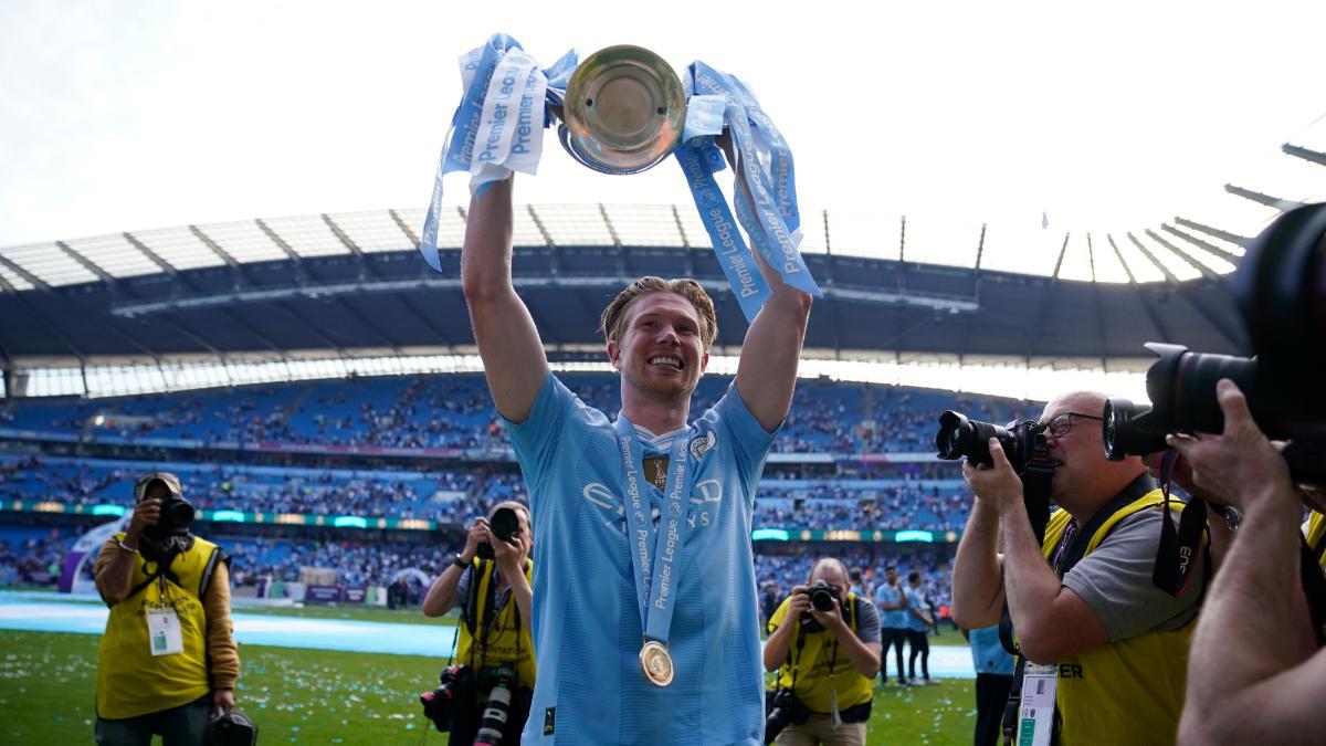 Kevin de Bruyne, junto al título de la Premier League conseguido por el Manchester City el pasado fin de semana