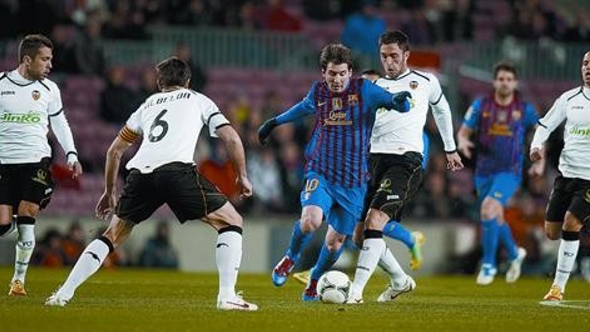 Messi, totalmente  rodeado de contrarios, trata de superar la entrada de Ruiz.