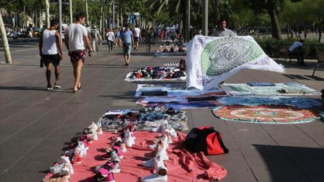 Hilera de manteros en el paseo Joan de Borbó, en la Barceloneta.