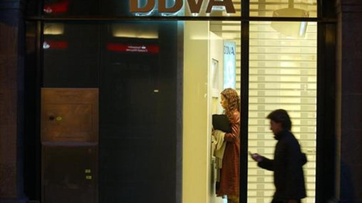 Una mujer utiliza un cajero de una oficina del BBVA en Barcelona.